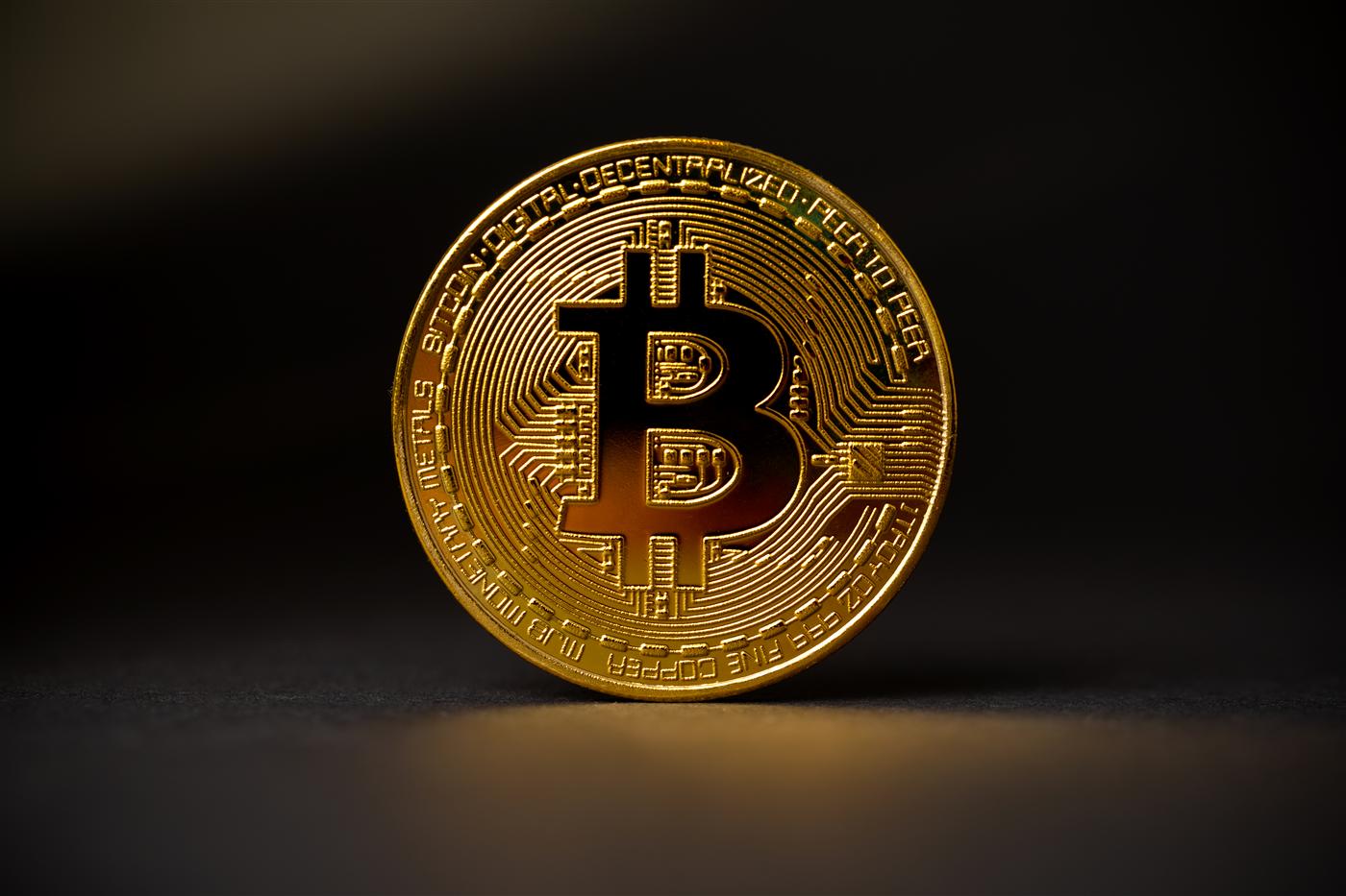 A physical Bitcoin coin on a dark surface